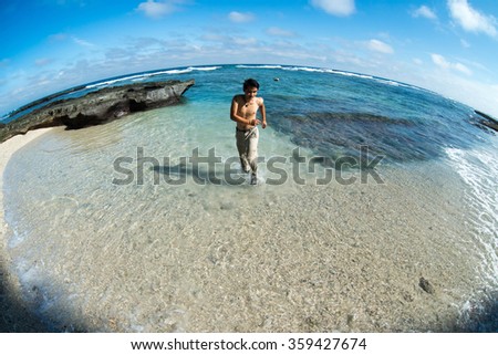 Young man enjoy in transparent beach in Ly Son island, Quang Ngai, Vietnam. Traveler explore the beach.