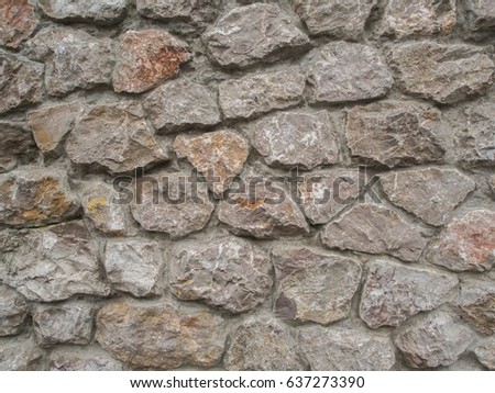 The Wall Of Multi Coloured Stones Agglomerated With Cement Mortar The Wall Of Multi Coloured Stones Agglomerated With Cement Mortar