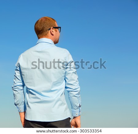 The man turned his back. Man standing and looking the skyline. Blue sky ...