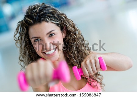 Fit woman at the gym lifting weights