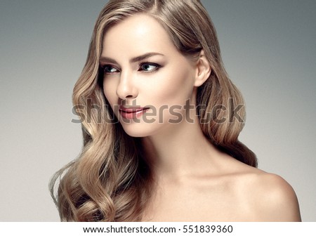 Amazing woman portrait. Beautiful girl with long wavy hair. Blonde model with hairstyle