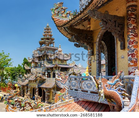 The Linh Phuoc Pagoda in mosaic style from shards of glass, pottery and porcelain in Da Lat city (Dalat) on the blue sky background in Vietnam. Da Lat is a popular tourist destination of Asia.