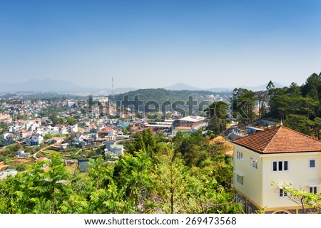 House with tile roof and a beautiful view of Da Lat city (Dalat) on the blue sky background in Vietnam. Da Lat is a popular tourist destination of Asia.