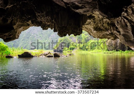 Scenic view of the Ngo Dong River from natural karst grotto at the Tam Coc portion, Ninh Binh Province, Vietnam. The river flows through cave. The Tam Coc is a popular tourist attraction in Vietnam.