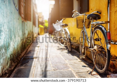 Bicycles parked near yellow wall of old house on sunny street in summer. Hoi An Ancient Town (Hoian), Vietnam. Hoi An Ancient Town is a popular tourist destination of Asia.
