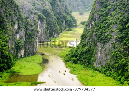 Top view of the Ngo Dong River and boats at the Tam Coc portion, Ninh Binh Province, Vietnam. Landscape formed by karst towers and rice fields. The Tam Coc is a popular tourist attraction in Vietnam.