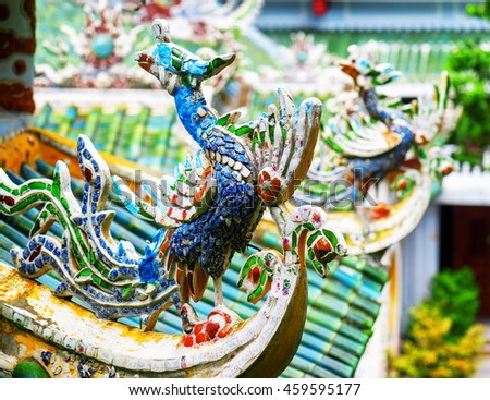 Colorful mosaic roof detail at the Linh Ung Pagoda in the Marble Mountains, Danang (Da Nang), Vietnam. The Marble Mountains is a popular tourist destination of Asia. Focus on the first sculpture.