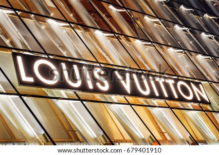 Singapore - February 17, 2017: Glowing logo of Louis Vuitton store by Marina Bay in Singapore. The luxury fashionable store in Singapore is a popular tourist attraction of Asia.