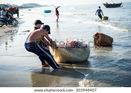 Long Hai, Ba Ria - Vung Tau, Vietnam - 31 May 2015: Fishermen carrying net back home from a long trip at Long Hai, Ba Ria - Vung Tau, Vietnam