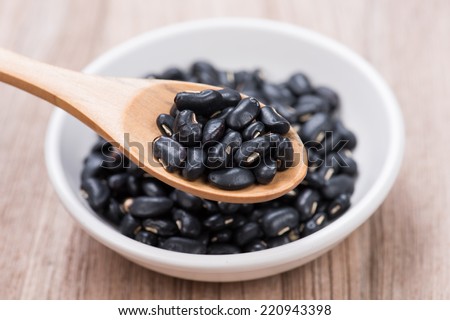 Black Beans in wooden spoon with ceramic bowl