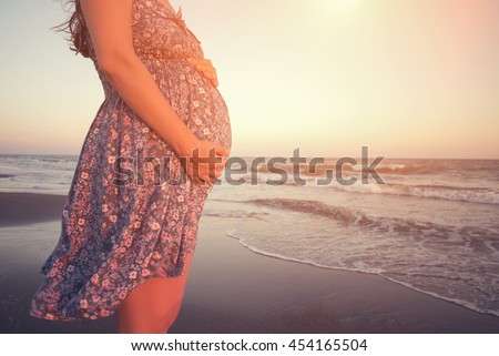 https://thumb1.shutterstock.com/display_pic_with_logo/1322491/454165504/stock-photo-pregnant-woman-holding-her-belly-on-the-beach-with-copy-space-454165504.jpg