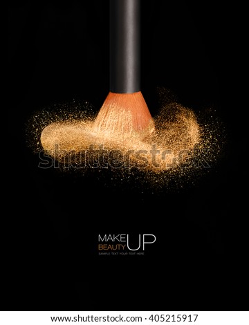 Makeup concept with a single professional makeup brush with glowing face powder isolated on black background with copy space and sample text