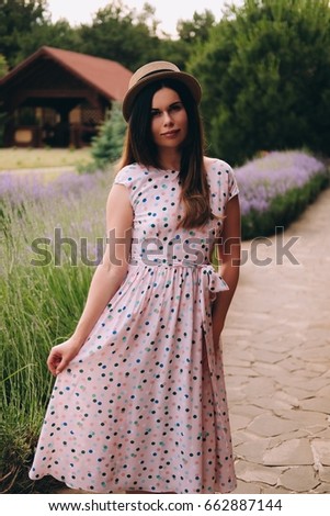 https://thumb1.shutterstock.com/display_pic_with_logo/1357633/662887144/stock-photo-young-beautiful-woman-in-long-dress-with-colored-polka-dots-and-stylish-hat-enjoys-good-weather-in-662887144.jpg