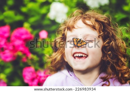 Laughing girl with a butterfly on his nose.