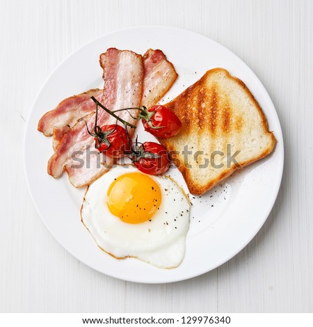 Breakfast with Fried egg and bacon on plate - stock photo