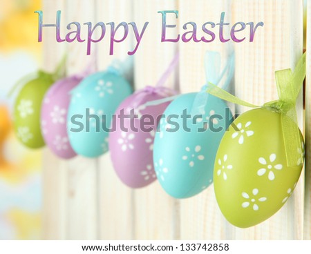 Art Easter background with eggs hanging on fence - stock photo