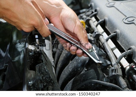 Hand with wrench. Auto mechanic in car repair
