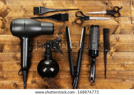 Hairdressing tools on wooden table close-up