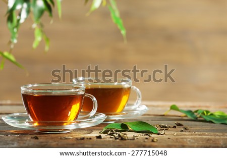 Cups of green tea on table on wooden background