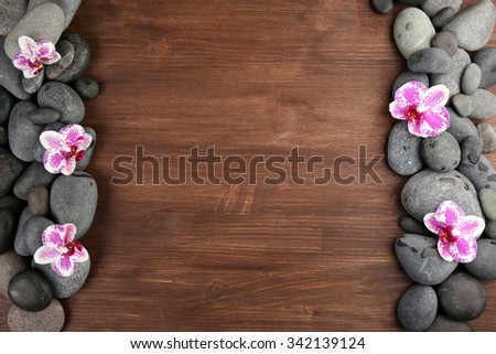 Spa stones and orchid on wooden background
