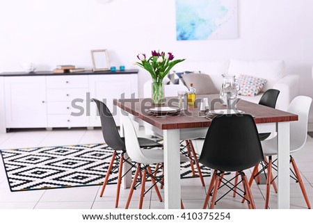 Modern living room. Furniture set with table and chairs. Bouquet of beautiful purple tulips on the table