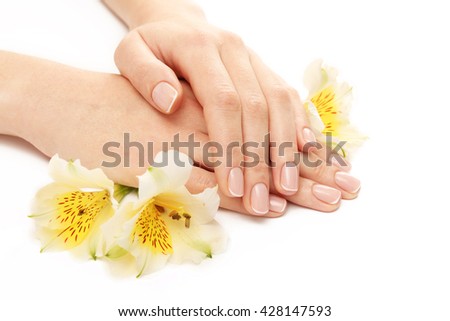 Woman hands with beautiful manicure and white lily isolated on white background