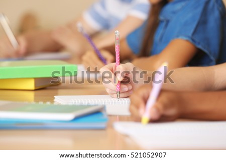 Children hands writing in copybooks, closeup