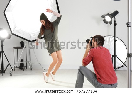 Beautiful young model posing for professional photographer in studio