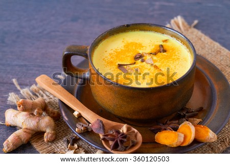Healthy drink made from turmeric roots, exotic spices with milk and honey