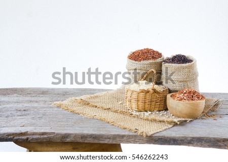 Asian group of grain rice,black rice,red rice ,rice riceberry in gunny bag on old wooden isolate on white background