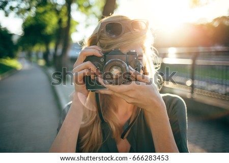 Hipster photographer using retro camera. Tourist girl capturing the moment