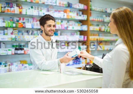 Experienced pharmacist counseling female customer in modern pharmacy