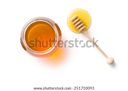 honey dipper and honey in jar on white background