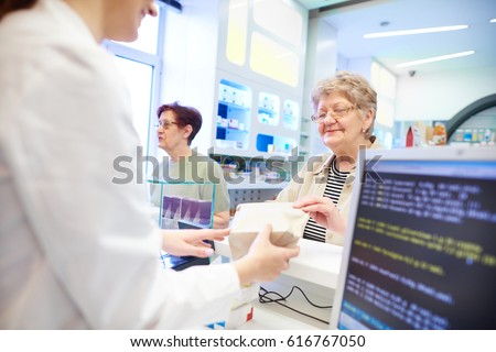 Pharmacist handing medication to customer