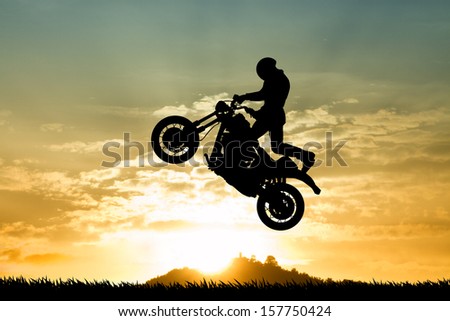 stuntman motorcyclist at sunset