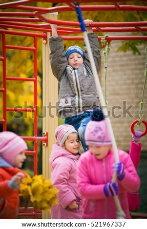 children play on the playground outside. A group of children playing together in kindergarten outside