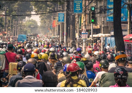 HO CHI MINH CITY, VIETNAM - FEBRUARY 2, 2013: traffic jam with a congestion of scooters and people with colorful helmets. There are approximately 340,000 cars and 3,5 million motorcycles in the city.