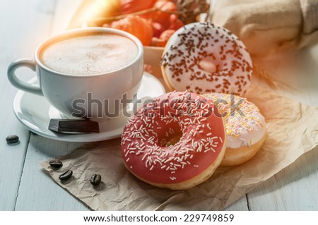 stock-photo-three-donut-and-a-cup-of-coffee-with-chocolate-on-a-white-table-229749859.jpg