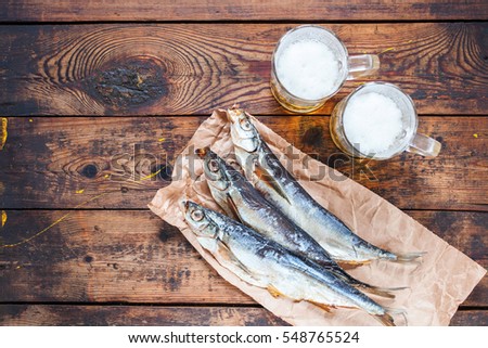 Sun-dried fish and beer on a wooden background. Selective focus. Copy space. Top view