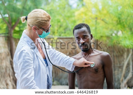 Médica caucasiana ouvindo a batida da lareira e a respiração do homem negro africano doente