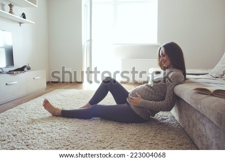 Home cozy portrait of pregnant woman resting at home and reading book