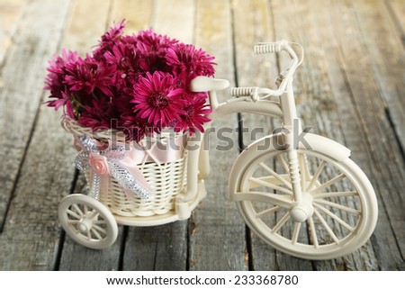 Beautiful chrysanthemums in bicycle on wooden background - stock photo