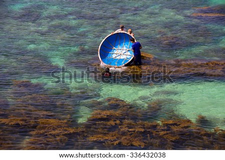 LY SON ISLAND-QUANG NGAI-VIETNAM. APRIL 26,2014. A view of fisher men on round boat in LY SON ISLAND - QUANG NGAI-VIETNAM