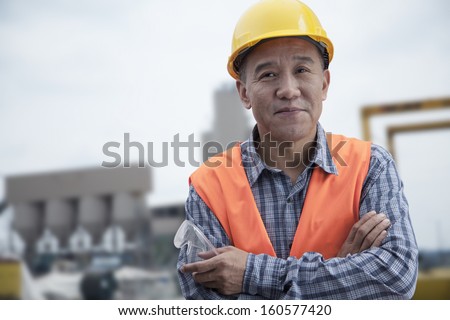 Portrait of proud worker with arms crossed in protective workwear