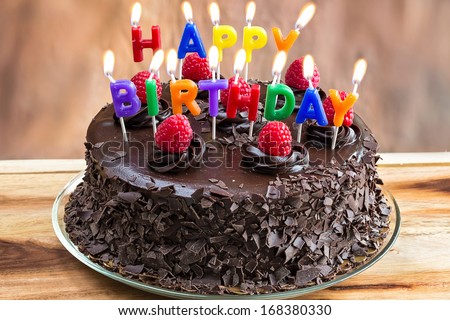 Happy Birthday candles on chocolate cake - stock photo