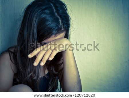 Sad and lonely girl crying with a hand covering her face (with space for text)