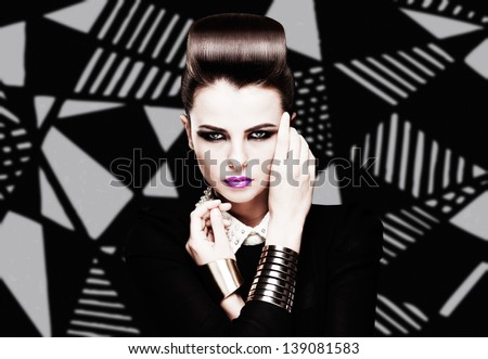 the sexy strict woman with violet lips and a fashionable hairstyle poses in studio on creative background