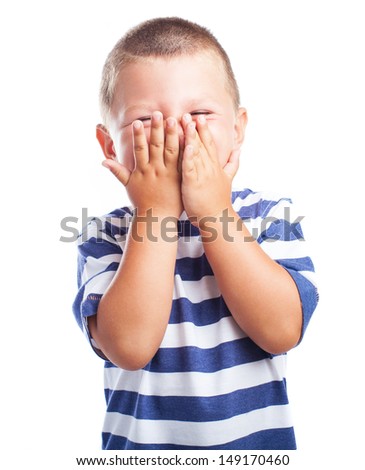Child laughing and covering his face with hands on white
