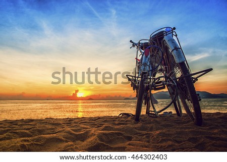 Young couple go to the beach to see the sunset and leave their bicycles on the beach in Nha Trang