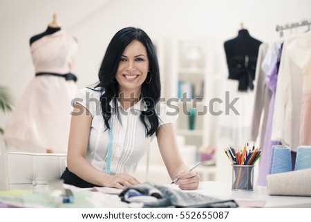 Smiling fashion designer working at her desk.